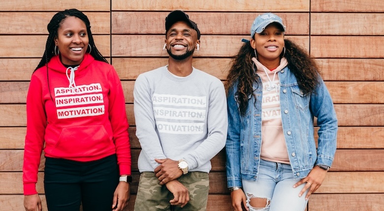 Group of diverse friends standing against wall and laughing